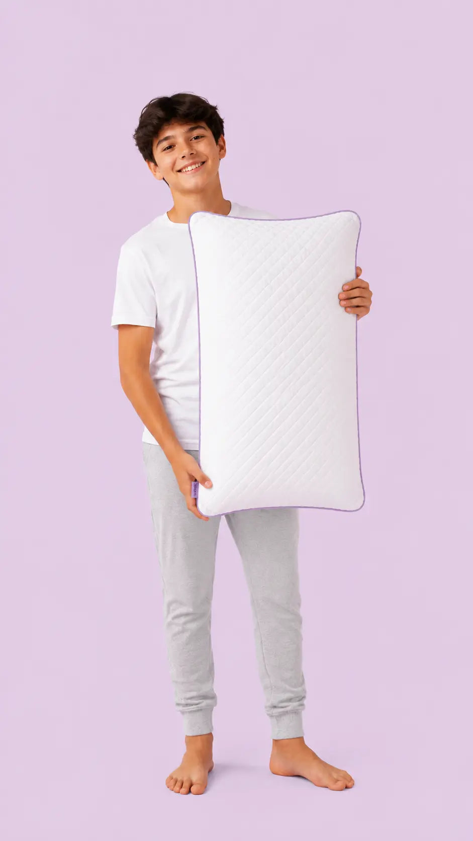 Young person holding the SORA Adjust ergonomic pillow — lifestyle image on lavender background