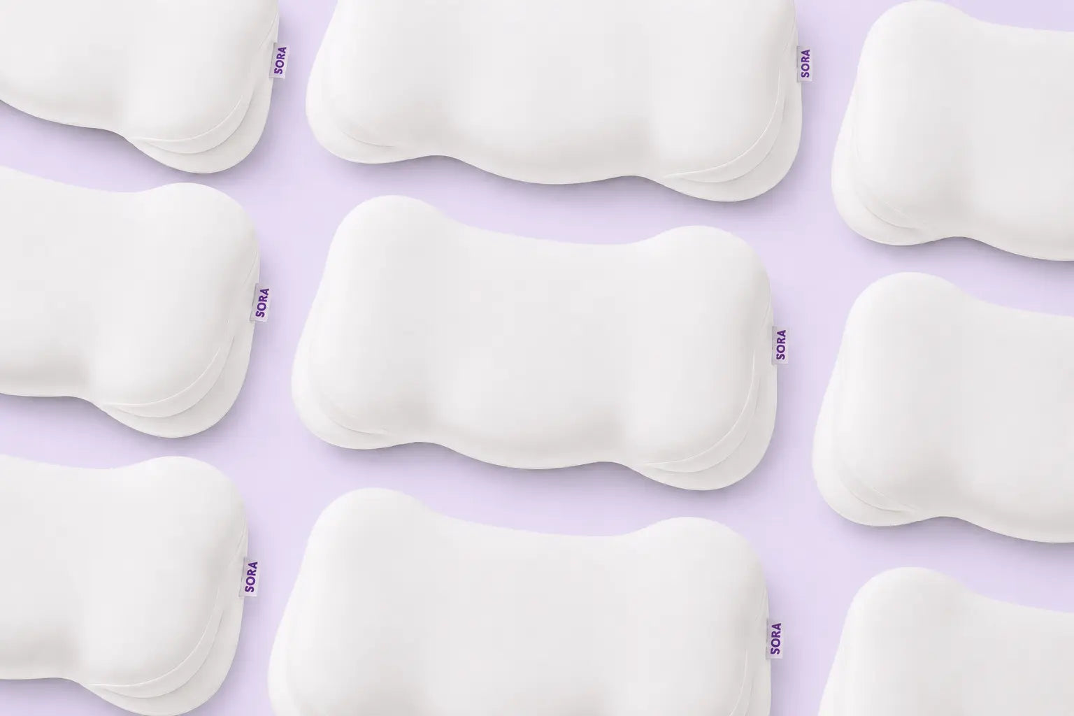 SORA Cloud ergonomic contoured pillows flat lay on lavender background — bone-shaped memory foam design for neck and shoulder support