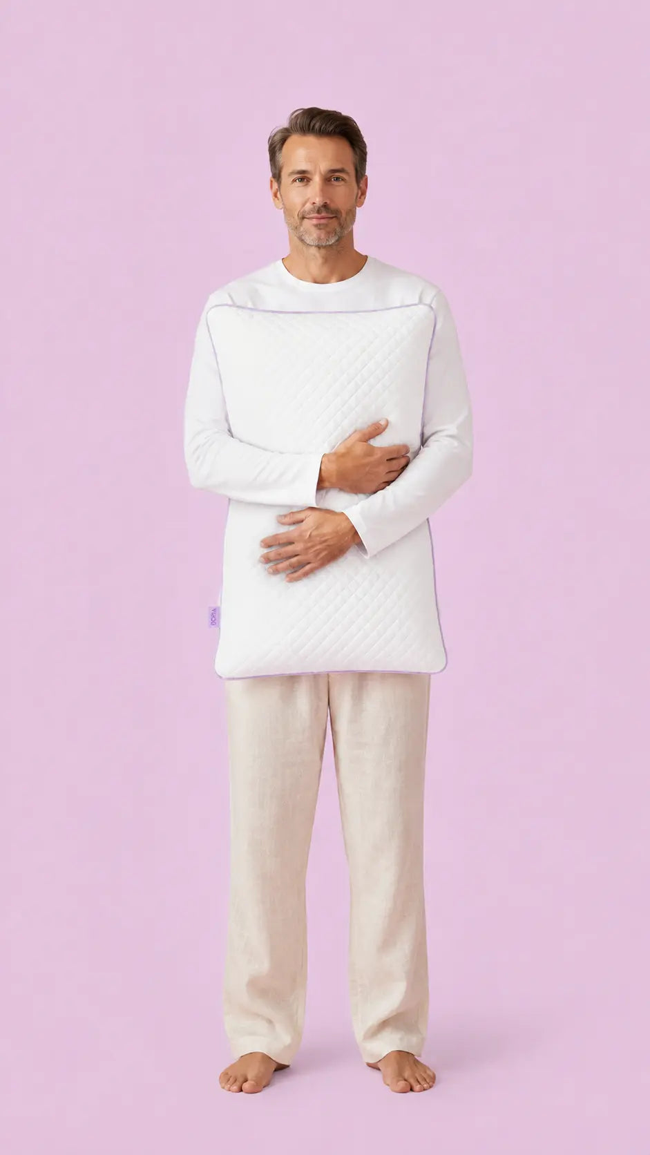 Man in pyjamas holding the SORA Adjust ergonomic pillow — lifestyle image on lavender background