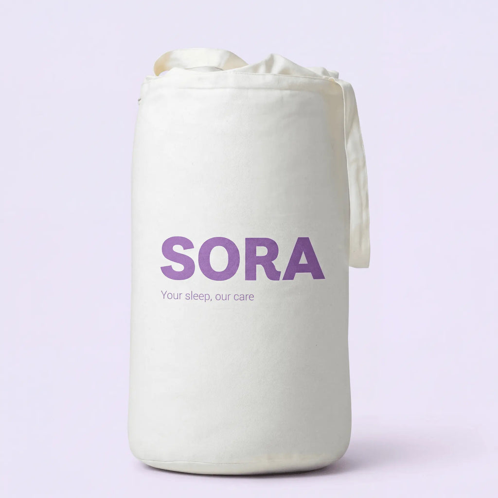 SORA Cloud ergonomic pillow shown from above on blush pink background with orange annotation arrows pointing to two zones. Soft Side for Back Sleepers at the top and Cervical Channel for Side Sleepers at the bottom